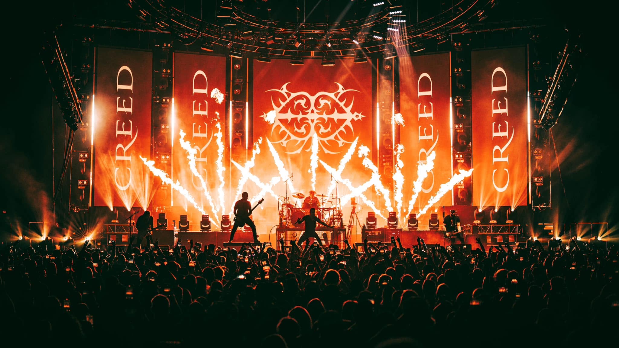Creed performing live with large stage visuals and pyrotechnics