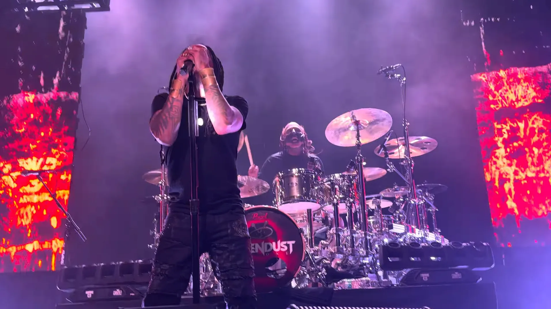 Sevendust performing amid purple light and red live visual panels
